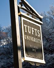 Tufts University sign, with trees in background.