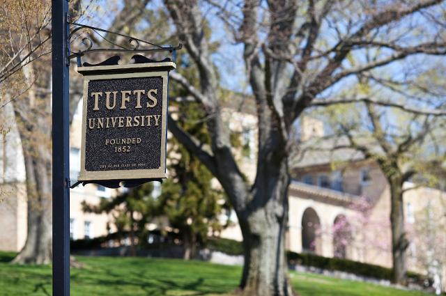Tufts University sign in front of tree.